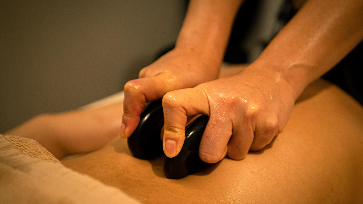 Therapist placing hot stones along the spine.